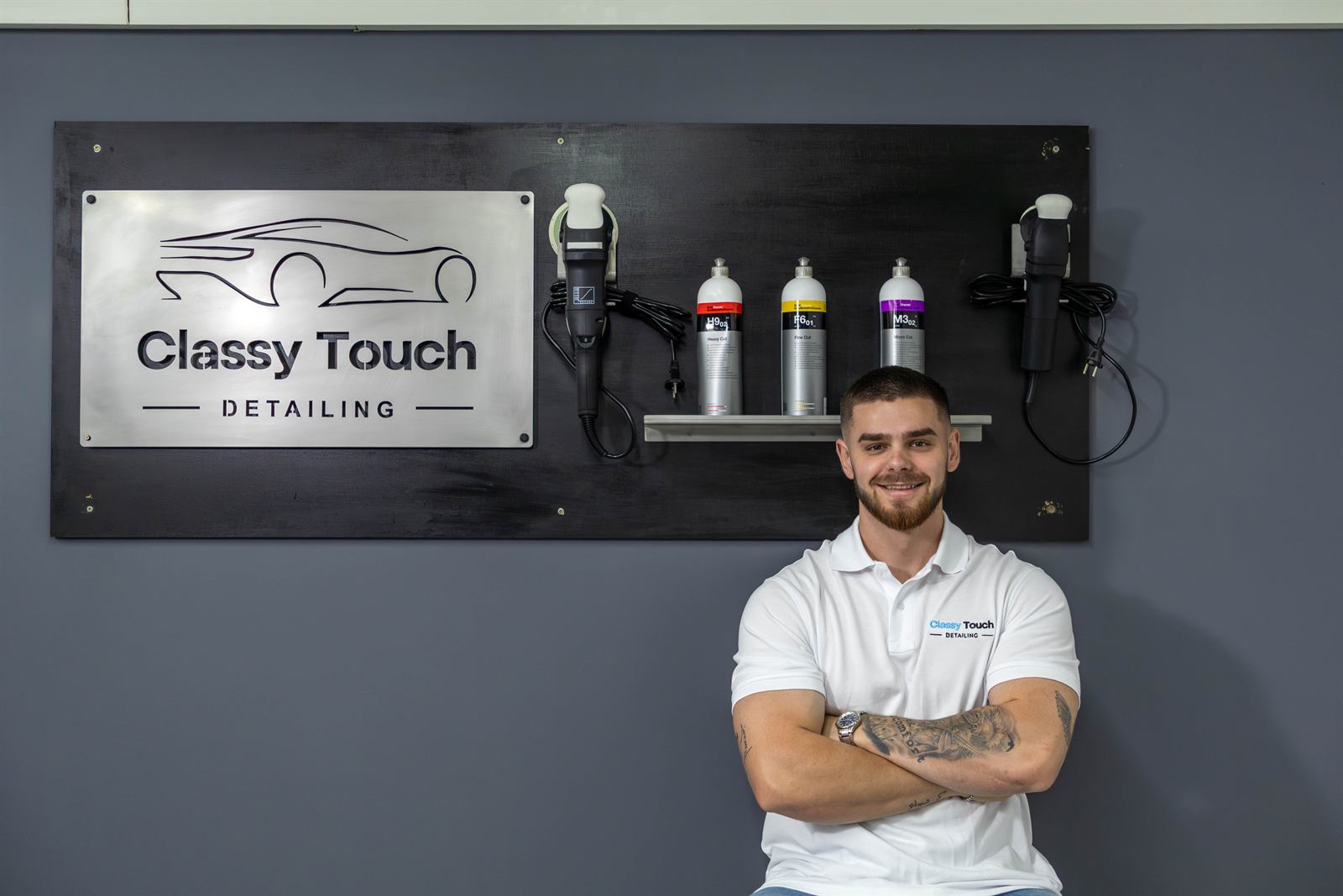 The Classy Touch detailer in the workshop, in front of the brand sign