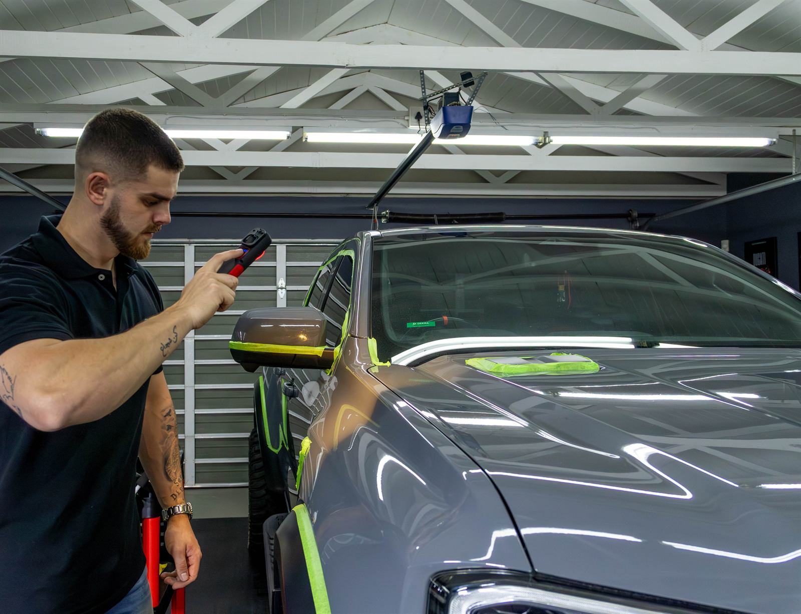 Detailer checking paintwork under an LED inspection light